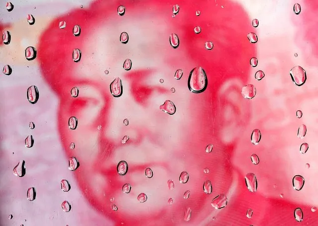A portrait of former Chinese leader Mao Zedong on a yuan banknote is reflected in water droplets in this picture illustration taken in Taipei October 8, 2010. (Photo by Nicky Loh/Reuters)