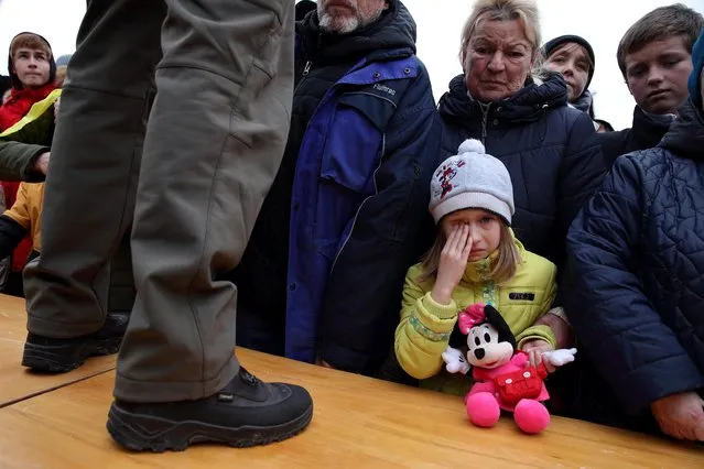 People wait to receive humanitarian aid in central Kherson, Ukraine on November 18, 2022. (Photo by Murad Sezer/Reuters)