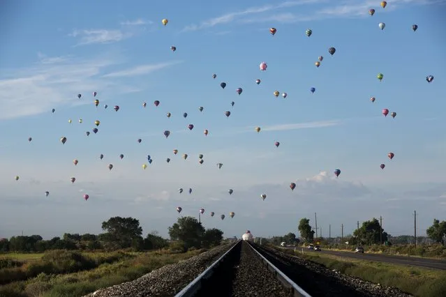 Hot air balloons lift off over railroad tracks during the 2015 Albuquerque International Balloon Fiesta in Albuquerque, New Mexico, October 7, 2015. (Photo by Lucas Jackson/Reuters)