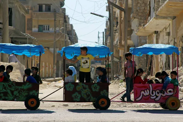 Children ride in carts on the third day of Eid al-Adha in the rebel controlled city of Idlib, Syria September 14, 2016. (Photo by Ammar Abdullah/Reuters)
