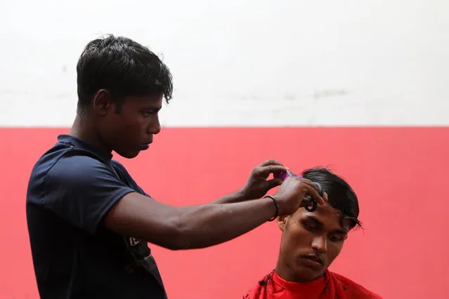 A Rohingya refugee gets their hair cut at a temporary shelter provided by the Aceh local goverment, in Pidie, Aceh, Indonesia, 28 December 2022. Local police said that 174 ethnic Rohingya migrants landed at Laweung Pidie Beach, Aceh Province in Indonesia on 26 December, after reportedly sailing for weeks at sea. According to a statement released on 27 December by the UN Refugee Agency (UNHCR), over 200 people were brought ashore to safety in north-west Indonesia over the past few days. Two groups, some 58 on 25 December, and 174, including a majority of women and children, on 26 December, were rescued and disembarked by Indonesian fishermen and local authorities, UNHCR added. (Photo by Hotli Simanjuntak/EPA/EFE)