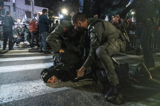 Israeli police officers take a demonstrator into custody as hundreds of people gather for a protest against Prime Minister Benjamin Netanyahu and his government and demanding his resignation and early elections in Tel Aviv, Israel on March 09, 2024. (Photo by Mustafa Alkharouf/Anadolu via Getty Images)