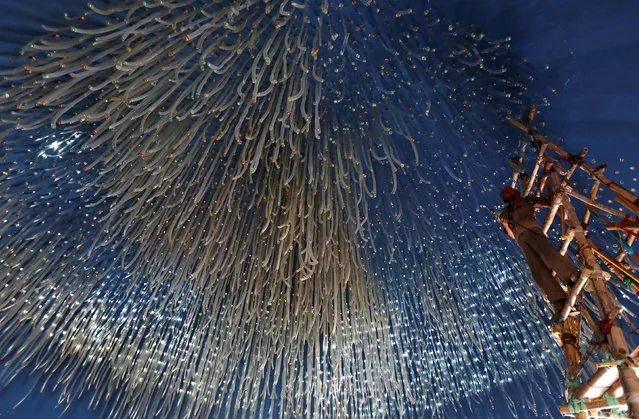 An electrician hangs decorative lights at a pandal, a temporary platform, for the upcoming Hindi festival of Durga Puja in Kolkata, India, September 23, 2016. (Photo by Rupak De Chowdhuri/Reuters)