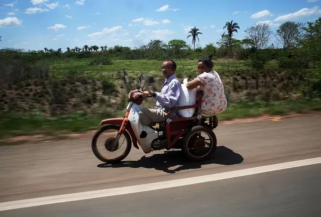 People ride a sccoter in a deforested section of the Amazon basin on November 24, 2014 in Maranhao state, Brazil. The non-governmental group Imazon recently warned that deforestation in the Brazilian Amazon skyrocketed 450 percent in October of this year compared with the same month last year. The United Nations climate change conference begins December 1 in neighboring Peru. (Photo by Mario Tama/Getty Images)