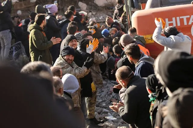 Rescuers applaud as a survivor is recovered from under the rubble at the site of a collapsed building, in the aftermath of a deadly earthquake in Kahramanmaras, Turkey on February 8, 2023. (Photo by Stoyan Nenov/Reuters)