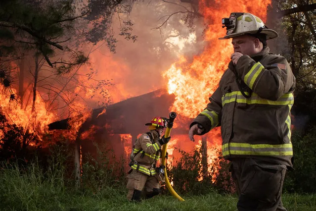 Local firefighters Richard LeBlanc and Richard Devlin respond to a house fire in the aftermath of Hurricane Delta in Lafayette, Louisiana, U.S., October 11, 2020. The fire was most likely caused by a damaged electrical line, firefighters on the scene said. (Photo by Adrees Latif/Reuters)