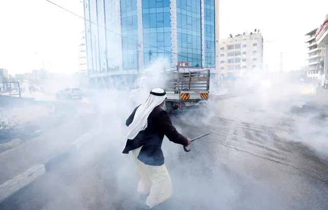 A Palestinian runs from tear gas fired by Israeli troops during clashes at a protest against U.S. President Donald Trump's decision on Jerusalem, near Ramallah, in the occupied West Bank March 16, 2018. (Photo by Mohamad Torokman/Reuters)