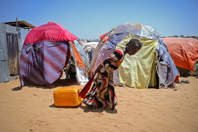 A Somali girl drags a jerrycan filled with water from a well at the Tawakal IDP camp on the outskirts of Mogadishu, Somalia, on March, 21, 2018. World Water Day, on March 22, 2018, calls attention on the importance of water, with this year's theme “Nature for Water” – exploring nature-based solutions to the water challenges we face in the 21st century. (Photo by Mohamed Abdiwahab/AFP Photo)