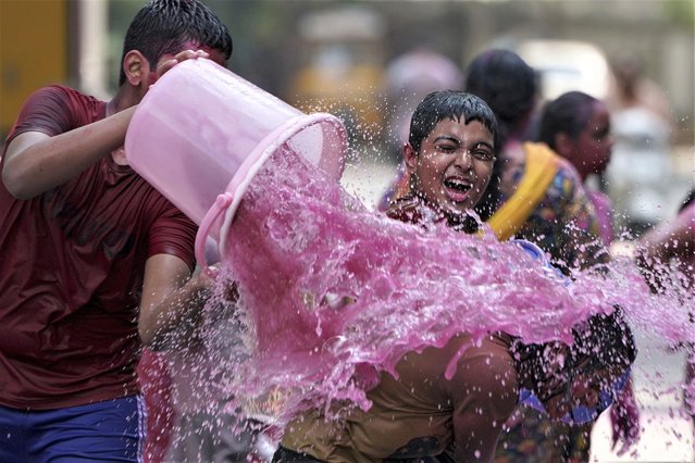Children play with color water as they celebrate Holi, the Hindu festival of colors, in Hyderabad, India, Tuesday, March 7, 2023. (Photo by Mahesh Kumar A./AP Photo)