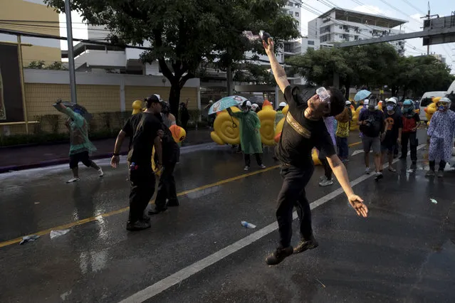 A pro-democracy protester hurls a color paint ball as police fire water cannons during an anti-government rally near the Parliament in Bangkok, Tuesday, November 17, 2020. (Photo by Wason Wanichakorn/AP Photo)