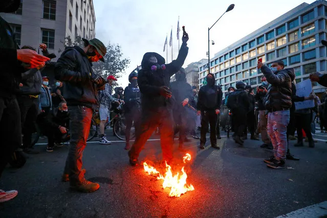 Demonstrators burn a flag during a “Stop the Steal” protest after the 2020 U.S. presidential election was called for Democratic candidate Joe Biden, in Washington, U.S. November 14, 2020. (Photo by Hannah McKay/Reuters)