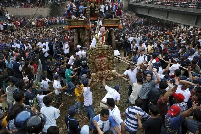Devotees pull the chariot of Rato Machhindranath through the Nakhu River during the chariot festival in Lalitpur, Nepal September 23, 2015. (Photo by Navesh Chitrakar/Reuters)