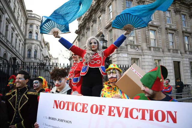 A woman in costume poses in front of a placard asking for the resignation of British Prime Minister, during a protest called by British influencer and youtuber Niko Omilana and staged in front of the Downing Street gates, in London, on February 6, 2022. British Prime Minister Boris Johnson suffered four staff defections on February 3, 2022 as pressure intensified on the embattled leader over lockdown parties and his loose-lipped style of politics. (Photo by Daniel Leal/AFP Photo)