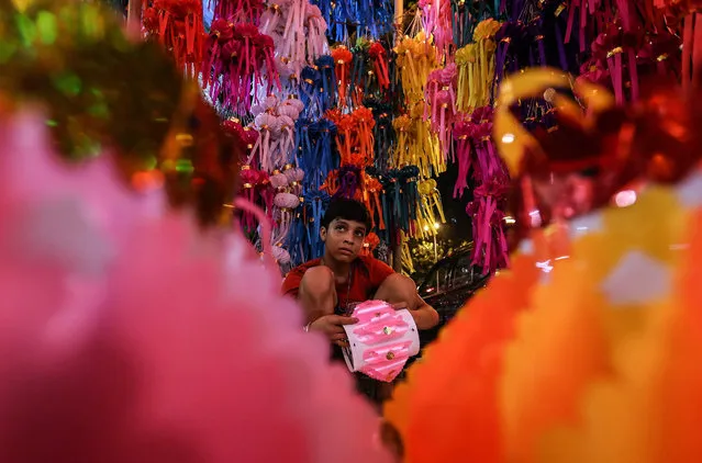 An Indian boy makes colorful lanterns on sale at a local market ahead of the Diwali festival in Mumbai, India, 03 November 2015. Diwali, the festival of lights symbolizing the victory of good over evil, commemorates Lord Ram’s return to his kingdom Ayodhya after completing his 14-year exile. (Photo by Divyakant Solanki/EPA)