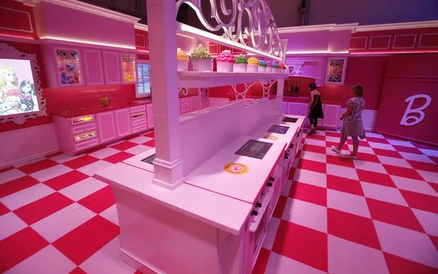 Girls watch the kitchen inside a life-size “Barbie Dreamhouse” of Mattel's Barbie dolls during a media tour in Berlin, May 15, 2013. (Photo by Fabrizio Bensch/Reuters)