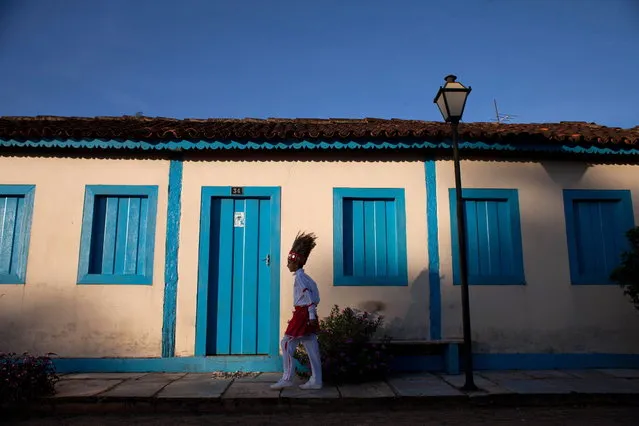 A boy dressed in a traditional costume walks to the “Cavalhadas” festival, in Pirenopolis, Brazil, Sunday, May 19, 2013. The popular festival is a tradition that was introduced in the 1800's by a Portuguese priest to mark the the ascension of Christ. The 3-day festival reenacts the Christian knights' defeat of the Moors. (Photo by Eraldo Peres/AP Photo)