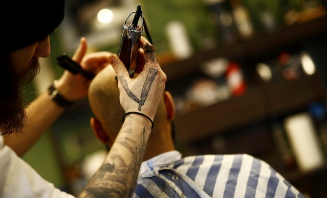 Alex “Torreto” Vellios, a 26-year old barber shaves the head of his assistant Sam at his Torreto barber shop in Frankfurt January 6, 2015. (Photo by Kai Pfaffenbach/Reuters)