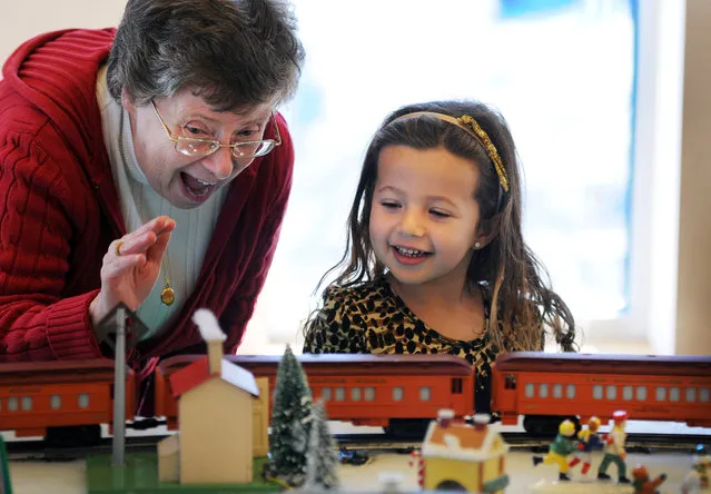 Diane Adler, Trustee from the Mahwah Museum, shares a moment with Ella Ledbery (age 4) of Mahwah as they watch  giant O gauge electric trains in the Children's Library in Mahwah Library. The trains were donated by  Mr. and Mrs. Margolis owners of Kinchley's Tavern to the Mahwah Museum in Mahwah, N.J., Sunday, November 8, 2015. (Photo by Mitsu Yasukawa/The Record of Bergen County via AP Photo)