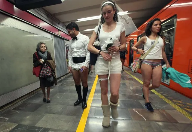An elderly woman, left, looks at a man who lacks his pants during the annual “No Pants Subway Ride” at a subway station in Mexico City, Sunday, January 11, 2015. The annual No Pants Subway Ride began in 2002 in New York as a stunt that organizers call “an international celebration of silliness”, and has spread to other cities. (Photo by Marco Ugarte/AP Photo)