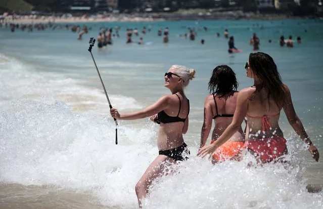 Swimmers pose for a selfie as waves hit the shore at Sydney's Bondi Beach during a heatwave that hit Australia's largest city, November 20, 2015. (Photo by Jason Reed/Reuters)