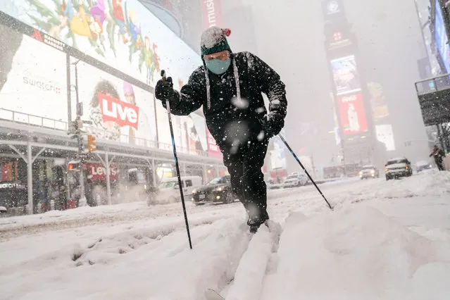 Steve Kent skis through Times Square during a snowstorm, Monday, February 1, 2021, in the Manhattan borough of New York. (Photo by John Minchillo/AP Photo)