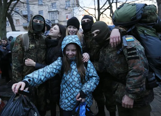 Volunteers being photographed with friends before being sent to the eastern part of Ukraine to join the ranks of special battalion “Azov” fighting against pro-Russian separatists, in Kiev, Ukraine, Saturday, January 17, 2015. (Photo by Sergei Chuzavkov/AP Photo)