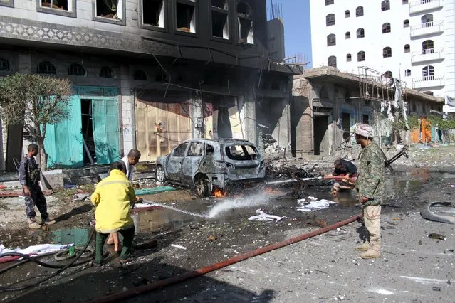 Firefighters and soldiers extinguish fire at the site of a car bomb attack in Yemen's central city of Ibb November 1, 2015. (Photo by Essam al-Kamali/Reuters)