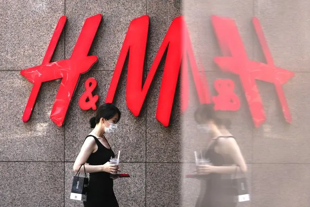 A woman walks by a Sweden-based clothing company H&M at a shopping mall in Beijing, Wednesday, June 21, 2023. Foreign companies are shifting investments and their Asian headquarters out of China as confidence plunges following the expansion of an anti-spying law and other challenges, a business group said Wednesday. (Photo by Andy Wong/AP Photo)
