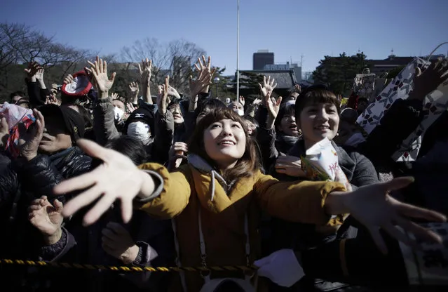 People try to catch lucky beans scattered by celebrities during “Mame-maki”, a bean throwing ceremony, at Zojyoji Buddhist temple in Tokyo, Tuesday, February 3, 2015. The ritual, performed annually to mark the beginning of the spring in the lunar calendar, is believed to bring good luck and drive away evil. (Photo by Eugene Hoshiko/AP Photo)