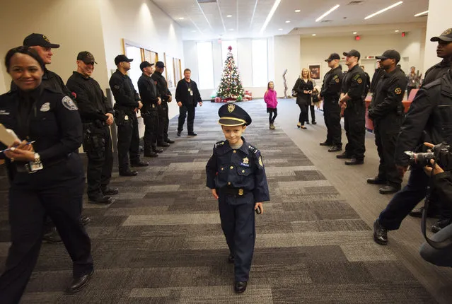 Detroit Police “Chief for a Day” Carter Widmer, 7, arrives at the Detroit Public Safety Headquarters on Wednesday, December 23, 2015, in Detroit. Widmer donated $250 of his Christmas money to the Detroit Police K-9 Unit. (Photo by John T. Greilick/Detroit News via AP Photo)