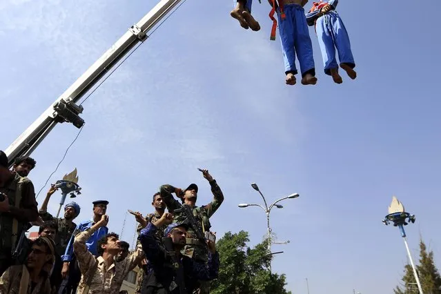 People gather as three persons convicted of raping and murdering a ten-year old boy, are hanged on a crane after they being shot dead at a public square in Sana'a, Yemen, 08 August 2018. (Photo by Yahya Arhab/EPA/EFE)