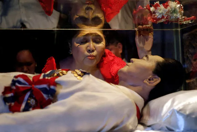Former first lady Imelda Marcos kisses the glass coffin of her husband, late president Ferdinand Marcos, who remains unburied since his death in 1989, during her 85th birthday celebration in Ferdinand Marcos' hometown of Batac, Ilocos Norte province, in northern Philippines July 2, 2014. (Photo by Erik De Castro/Reuters)