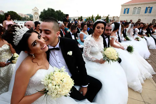 A groom kisser his bride as Lebanese Maronite Christian couples take part in a mass wedding at the Maronite Patriarchate in Bkerke on September 2, 2018. Fourty one couples got married during the event organised by the Maronite league for the ninth year in a row. (Photo by  Anwar Amro/AFP Photo)