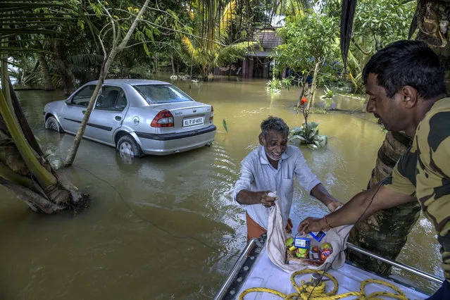 Border Security Force (BSF) distribute food food and water to residents who are stuck in their houses as well who have not vacated houses at Allapy on August 21, 2018 in Kerala, India. Over 400 people have reportedly died in the southern Indian state of Kerala after weeks of monsoon rains which caused the worst flooding in nearly a century and displaced more than one million people that have been forced to take shelter in thousands of relief camps across Kerala. Flood waters and rain have receded this week as the massive cleanup begins and the Indian armed forces continue efforts to rescue thousands of stranded people and get relief supplies to isolated areas. (Photo by Atul Loke/Getty Images)