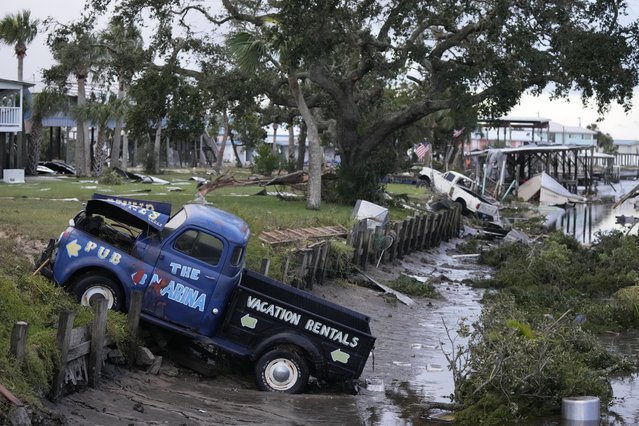 Pick up trucks and debris lie strewn in a canal in Horseshoe Beach, Fla., after the passage of Hurricane Idalia, Wednesday, August 30, 2023. (Photo by Rebecca Blackwell/AP Photo)