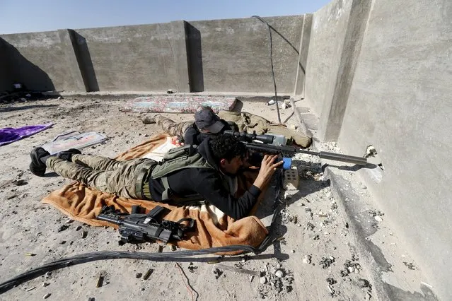 An Iraqi security forces sniper looks through the scope of his rifle as he guards in the city of Ramadi, January 16, 2016. Baghdad and Washington have touted Ramadi as the first major success for Iraq's U.S.-backed army since it collapsed in the face of Islamic State's lightning advance across the country's north and west in mid-2014. But the scorched-earth battlefield tactics used by both sides mean the prize is a shattered ruin. (Photo by Thaier Al-Sudani/Reuters)