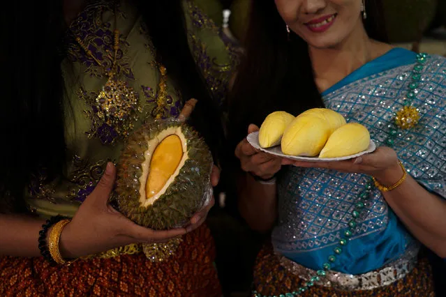 Women dressed in Thai traditional costumes hold durians at a department store in Bangkok, Thailand, April 26, 2018. (Photo by Athit Perawongmetha/Reuters)