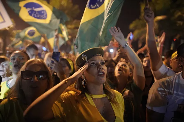 A supporter of Jair Bolsonaro salutes during a celebration in front of his residence after he was declared the winner of the election runoff, in Rio de Janeiro, Brazil, Sunday, October 28, 2018. Bolsonaro, a brash far-right congressman who has waxed nostalgic for Brazil's old military dictatorship, won the presidency of Latin America's largest nation Sunday as voters looked past warnings that the former army captain would erode democracy and embraced a chance for radical change after years of turmoil. (Photo by Leo Correa/AP Photo)