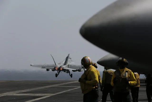 A U.S. military plane takes off from the flight deck of the USS Carl Vinson aircraft carrier in the Persian Gulf, Thursday, March 19, 2015. (Photo by Hasan Jamali/AP Photo)