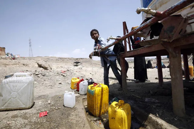 A displaced Yemeni boy collects water from a water tank at a camp for Internally Displaced Persons (IDPs) on the outskirts of Sana'a, Yemen, 08 June 2021. Oman is stepping up its diplomatic efforts in Yemen, trying to persuade the Houthi leaders to accept a nationwide truce and resume UN-sponsored peace talks with Yemen's Saudi-backed government on ending the prolonged conflict in the Arab country. The conflict has plunged Yemen into the world's largest humanitarian crisis with an estimated 80 percent of Yemen's 29 million-population are in need of humanitarian assistance, and left more than three million people, including 1.58 million children, internally displaced. (Photo by Yahya Arhab/EPA/EFE)