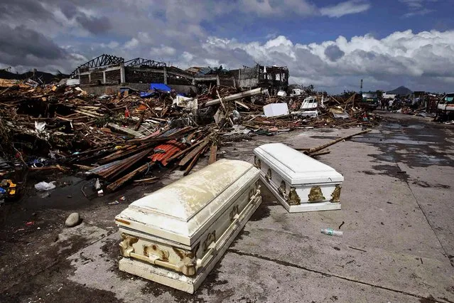 Empty coffins lie on a street near houses damaged after super Typhoon Haiyan battered Tacloban city. (Photo by Romeo Ranoco/Reuters)