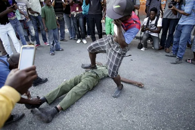 A man steps on an unidentified man in military style clothes who was stoned to death by a mob of protesters in Port-au-Prince, Haiti, February 5, 2016. Haiti slipped deeper into unrest on Friday as gangs of former soldiers roamed the capital and a mob of protesters beat a man to death with stones, following a botched election that has left no successor for outgoing President Michel Martelly. (Photo by Andres Martinez Casares/Reuters)