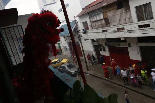 Dancers perform a lion dance on a balcony of the Yan Wo temple as locals look on during celebrations of the Chinese Lunar New Year of the Monkey in Chinatown in Panama City, Panama, February 8, 2016. (Photo by Carlos Jasso/Reuters)