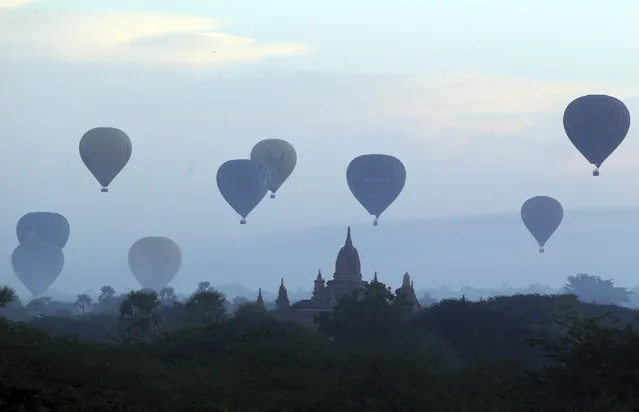 In this Sunday, December 16, 2018, photo, hot air balloons fly over the Myanmar's old temple just before sunrise in Bagan, Nyaung U district, central Myanmar. (Photo by Aung Shine Oo/AP Photo)