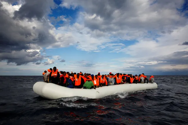 An overcrowded raft drifts out of control in the central Mediterranean Sea, some 36 nautical miles off the Libyan coast, before lifeguards from the Spanish NGO Proactiva Open Arms rescue all 112 on aboard, including two pregnant women and five children, January 2, 2017. (Photo by Yannis Behrakis/Reuters)