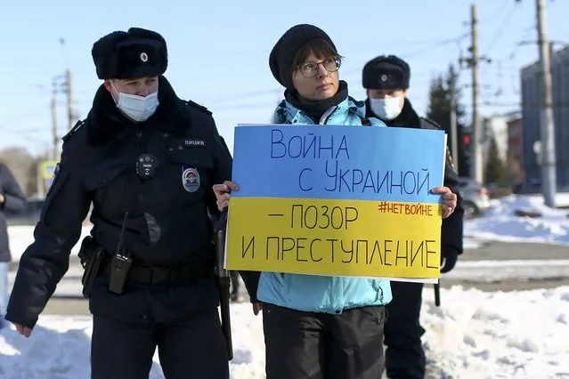 Police detain a demonstrator with a poster which reads “The war with Ukraine is a shame and a crime” during an action against Russia's attack on Ukraine in Omsk, Russia, Sunday, February 27, 2022. Western countries on Monday repeatedly called on Russia to end domestic repression of dissident voices and end its war in Ukraine and human rights violations related to it, as Russia came under a regular review at the U.N.’s top rights body. (Photo by Evgeniy Sofiychuk/AP Photo)