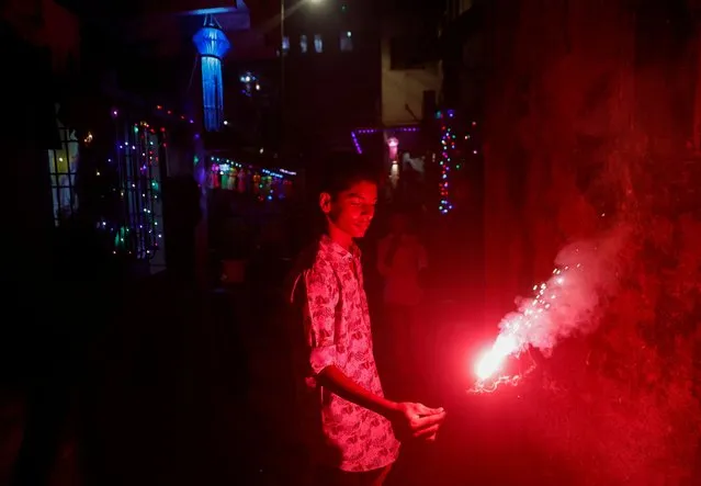 A boy holds a sparkler during Diwali, the Hindu festival of lights, in Mumbai, India on November 12, 2023. (Photo by Francis Mascarenhas/Reuters)
