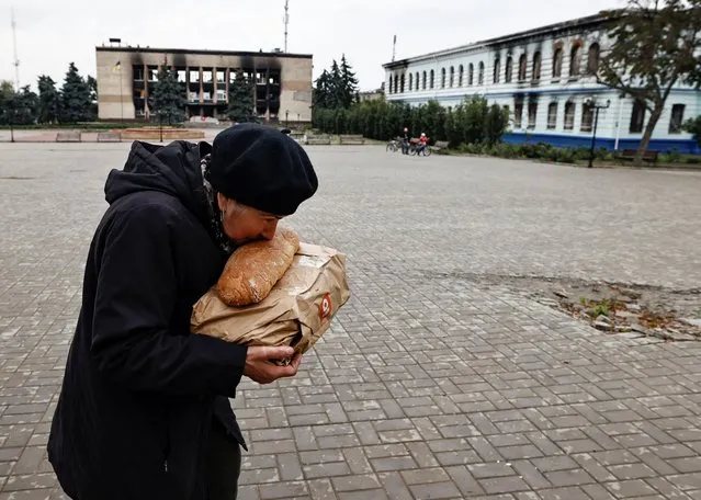 A local resident kisses bread after she received humanitarian aid, as Russia's attack on Ukraine continues, in the recently liberated town of Izium, in Kharkiv region, Ukraine on September 27, 2022. (Photo by Zohra Bensemra/Reuters)