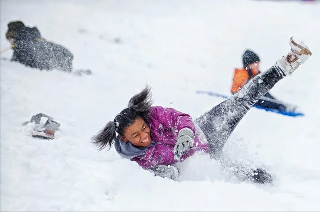 Jayla Rice, 13, wipes out after trying a friend's snowboard at Trench Hill in Fredericksburg, Va., Monday, February 15, 2016. (Photo by Dave Ellis/The Free Lance-Star via AP Photo)
