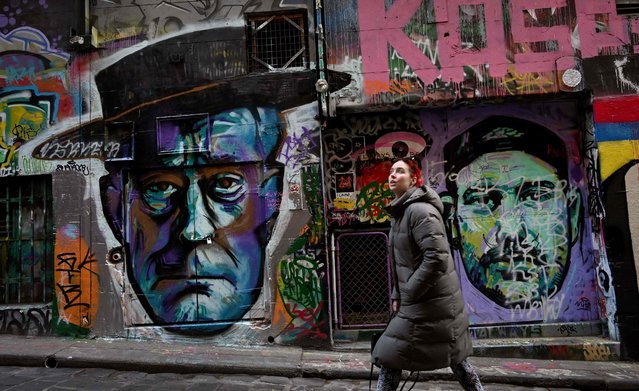 People walk past artworks in Melbourne's Hosier Lane on June 24, 2021 where street artists are able to paint at will, creating a tourist attraction in the city. (Photo by William West/AFP Photo)